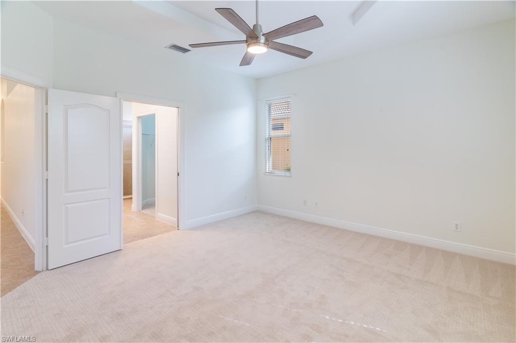 15313 Cortona Way Naples, FL 34120 - Photo 5 of 28 an empty room with closet and a ceiling fan
