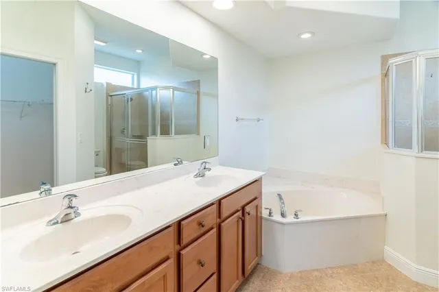 a bathroom with a tub sink and mirror