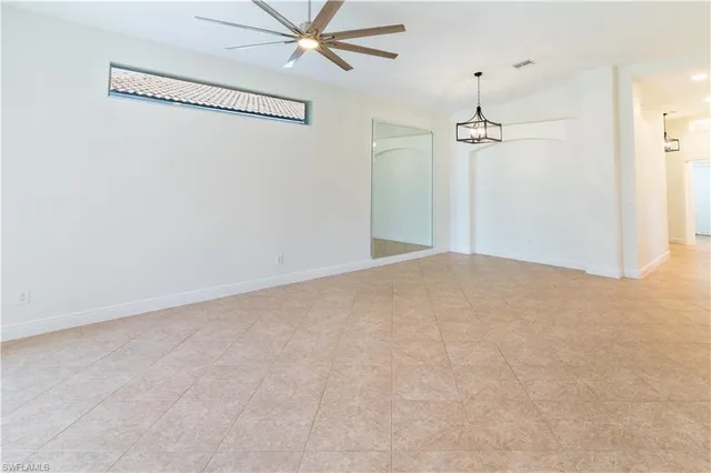en empty room with windows and ceiling fan