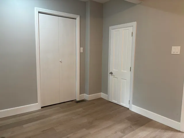 an empty room with wooden floor and closet