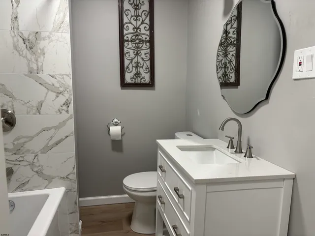 a bathroom with a sink mirror and toilet