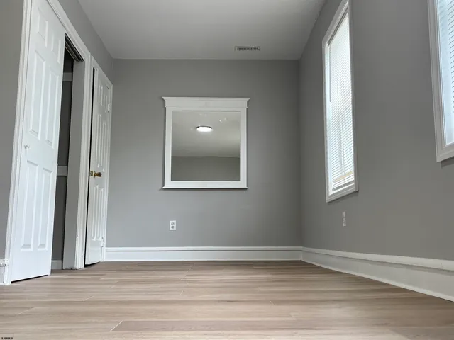 a view of a room with wooden floor and windows