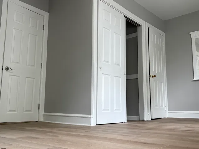 an empty room with wooden floor and entryway