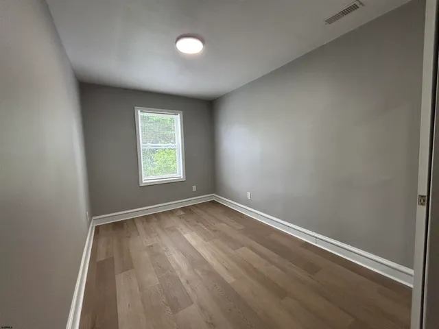 an empty room with wooden floor and closet