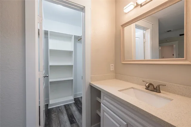 a bathroom with a granite countertop sink toilet a mirror and shower