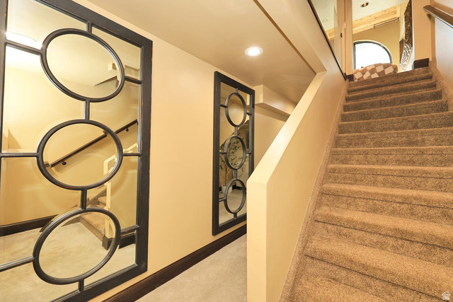 3104 East High Danish Road Sandy, UT 84093 - Photo 28 of 36 Carpeted staircase leading to walk out basement with recessed lighting and a decorative wall mirror featuring circular elements