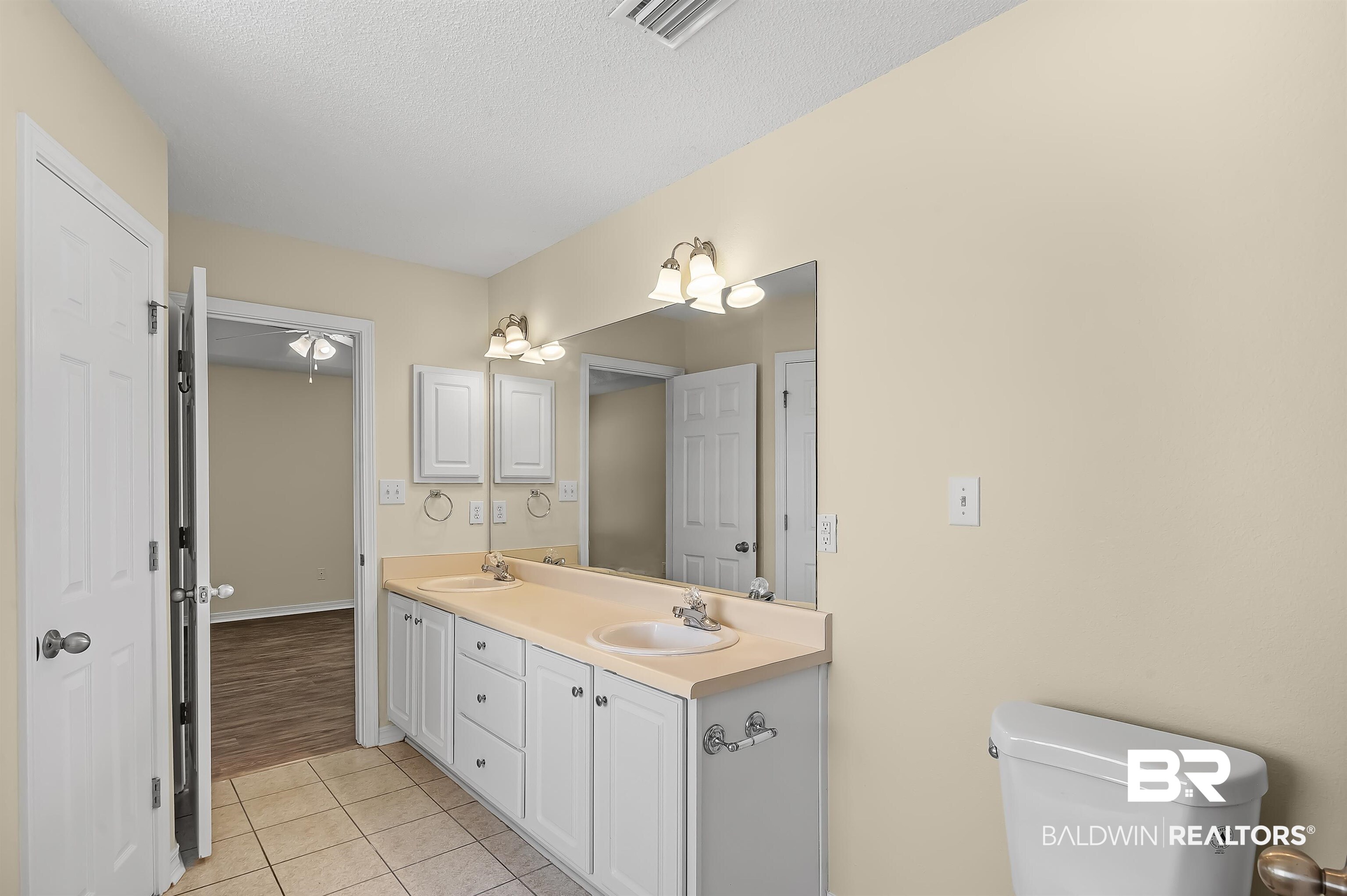 12443 Venice Boulevard Foley, AL 36535 - Photo 46 of 59 Bathroom with a textured ceiling, vanity, toilet, and wood-type flooring