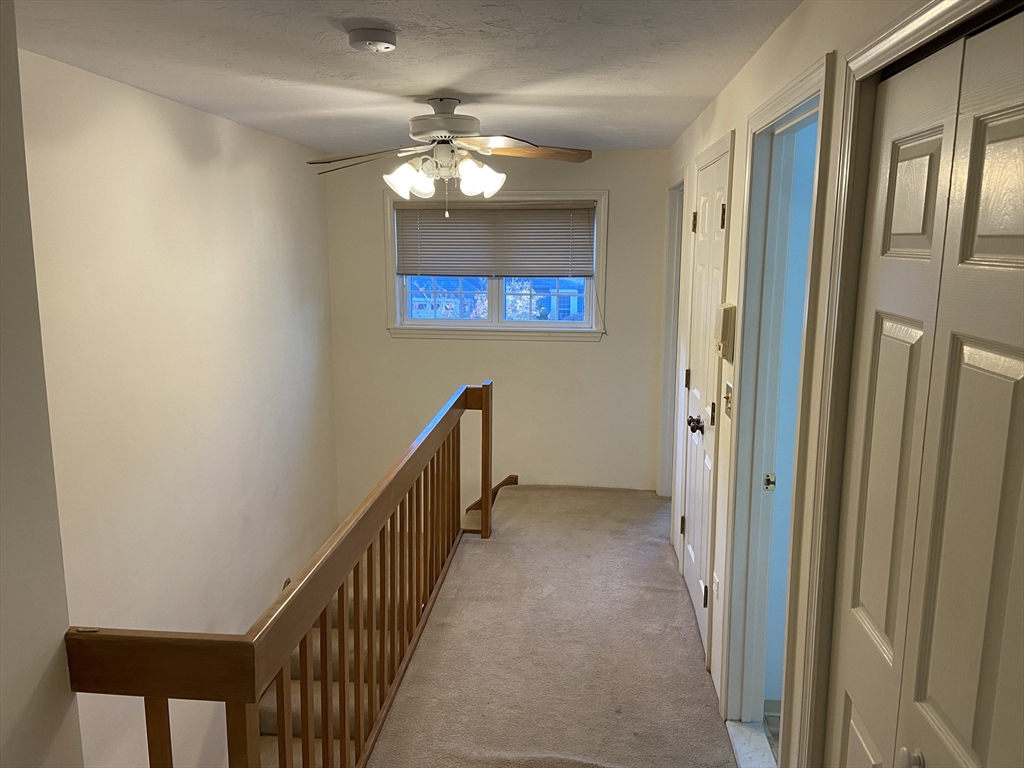 501 Ridgefield Circle, Unit B Clinton, MA 01510 - Photo 11 of 17 a view of a hallway with wooden floor and chandelier