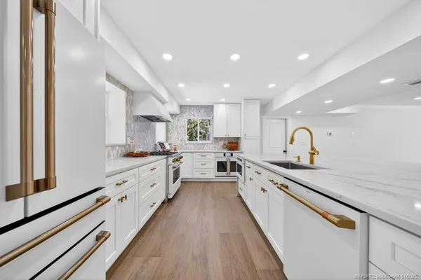 a kitchen with stainless steel appliances a white cabinets and window