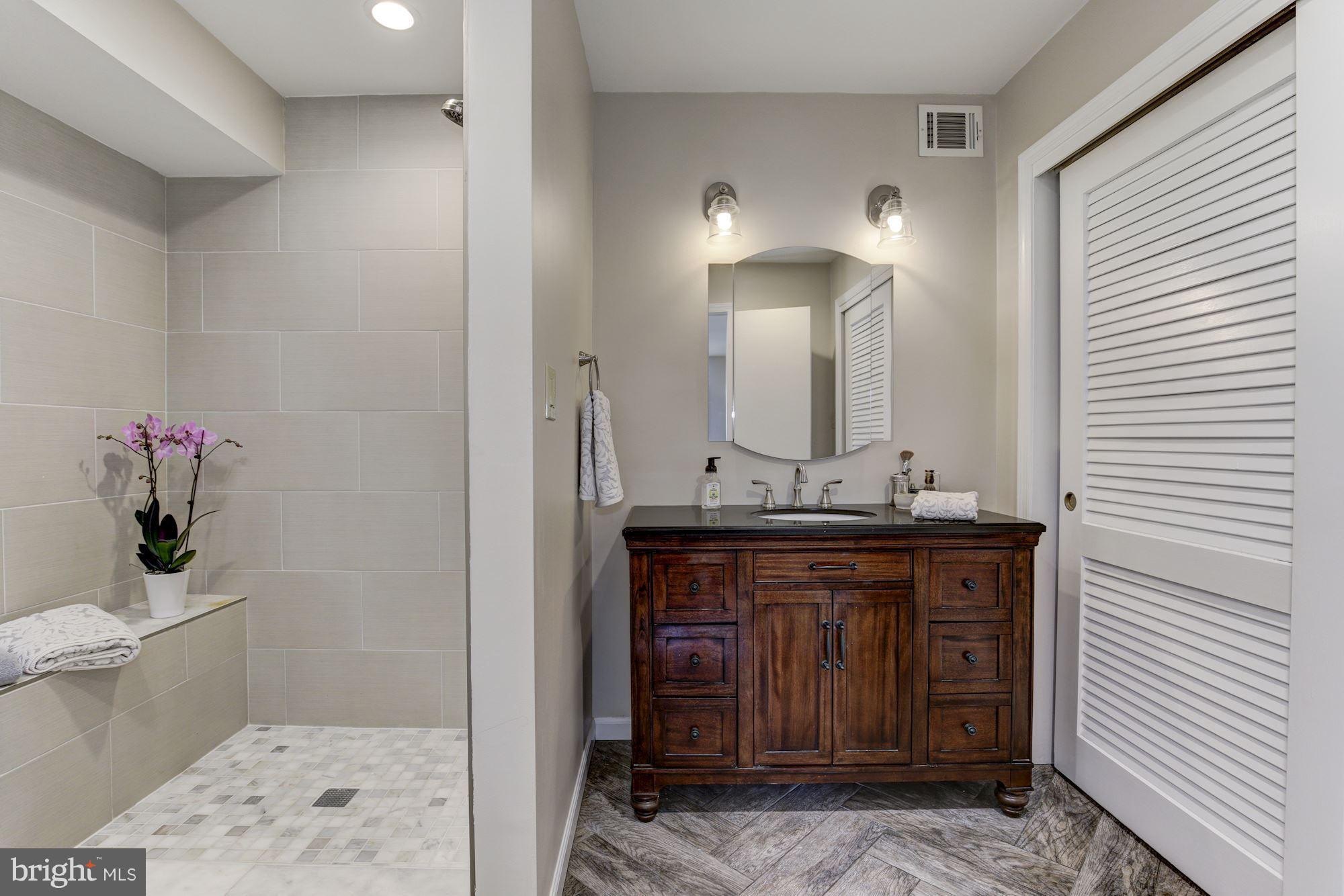 4801 Little Falls Road Arlington, VA 22207 - Photo 13 of 28 a bathroom with a granite countertop sink a toilet and mirror