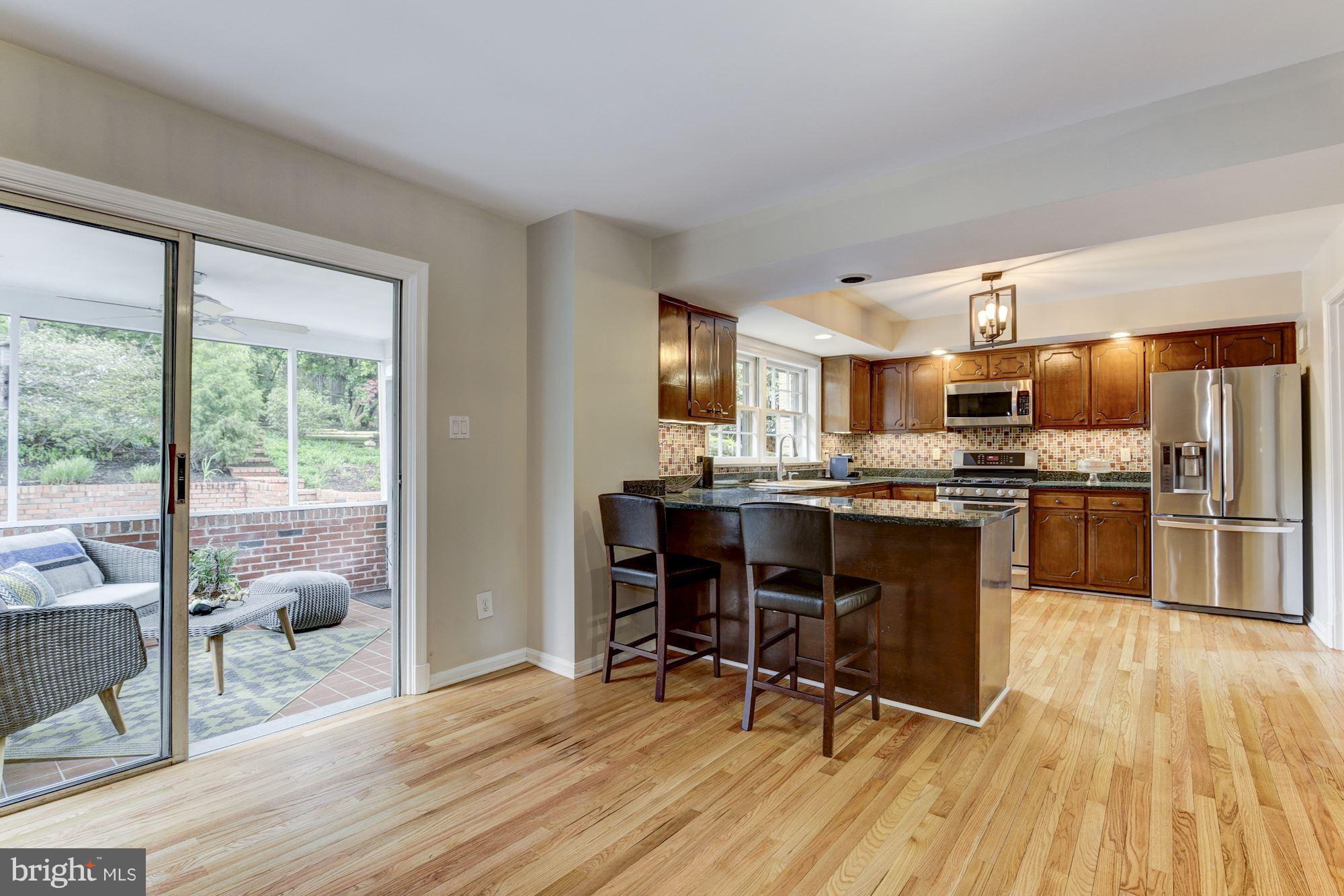 4801 Little Falls Road Arlington, VA 22207 - Photo 10 of 28 a kitchen with kitchen island granite countertop wooden floors and stainless steel appliances