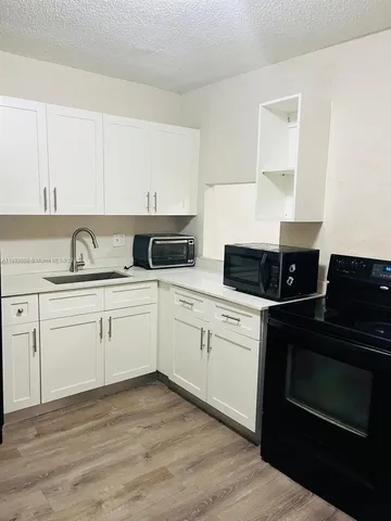a kitchen with appliances cabinets and a sink
