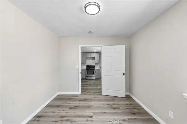 an empty room with wooden floor and closet
