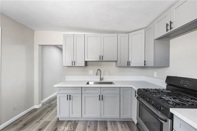 a kitchen with granite countertop a sink stove and cabinets