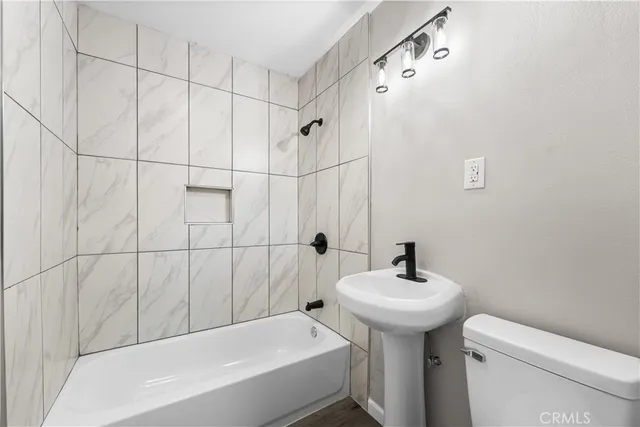 a bathroom with a sink a toilet and shower