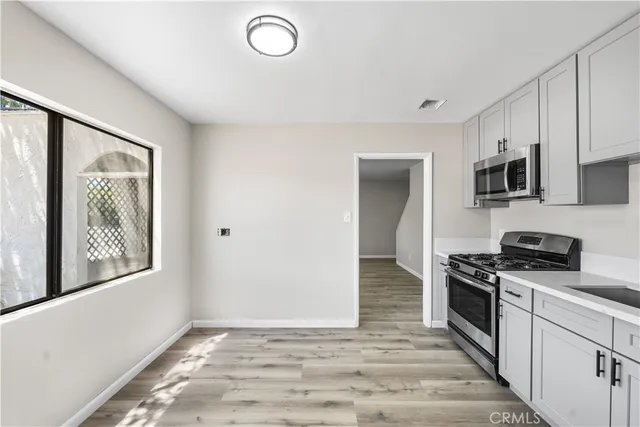 a kitchen with stainless steel appliances granite countertop a stove top oven a sink and a microwave