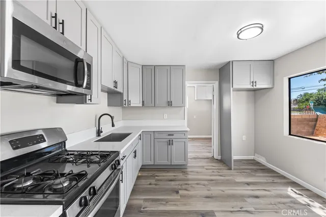 a kitchen with stainless steel appliances a stove a sink and a microwave