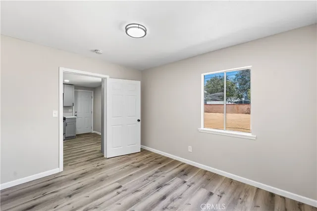 an empty room with wooden floor and a window