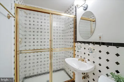 a bathroom with a sink mirror and shower