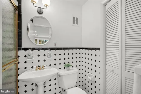 a bathroom with a sink a toilet and a mirror