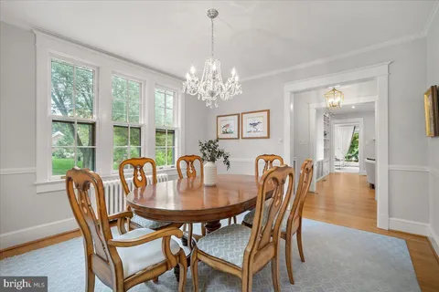 a dining room with furniture a chandelier and wooden floor