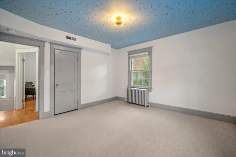 an empty room with windows and closet