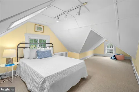 a spacious bedroom with a bed and a chandelier