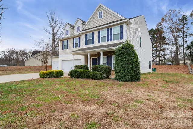 a view of a house with backyard and trees