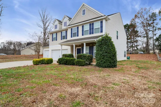 a view of a house with backyard and trees