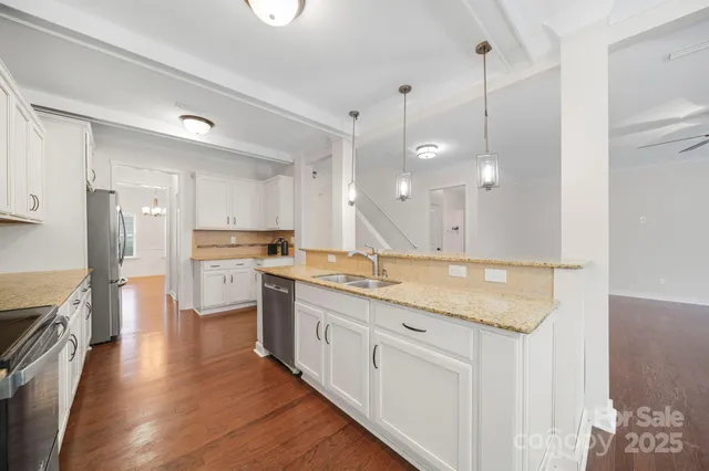 a kitchen with stainless steel appliances granite countertop a lot of counter space and wooden floors