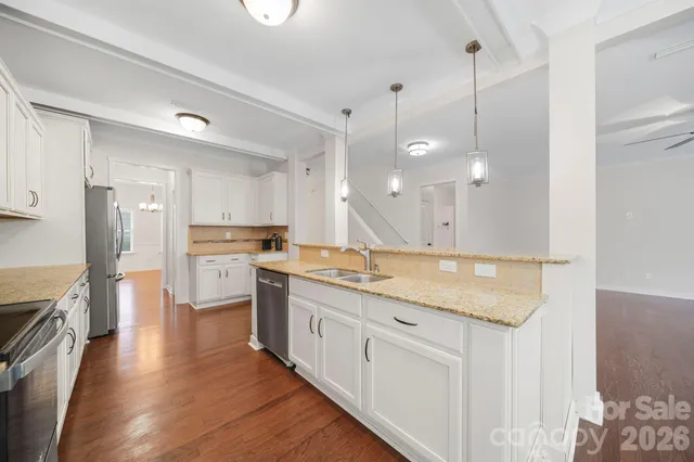 a kitchen with stainless steel appliances granite countertop a lot of counter space and wooden floors