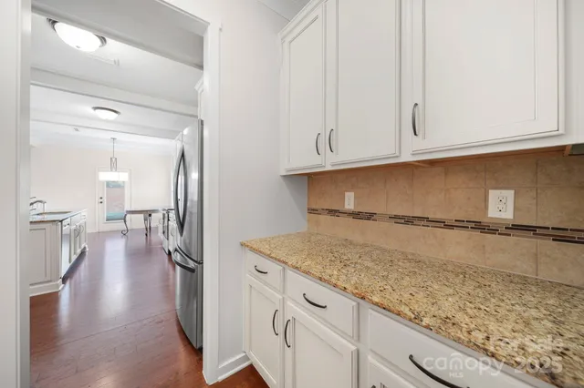 a view of a kitchen with white cabinets