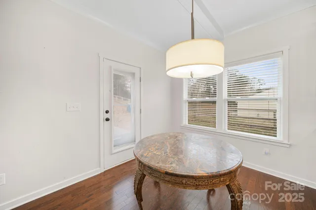 a view of a room with a chandelier and wooden floor