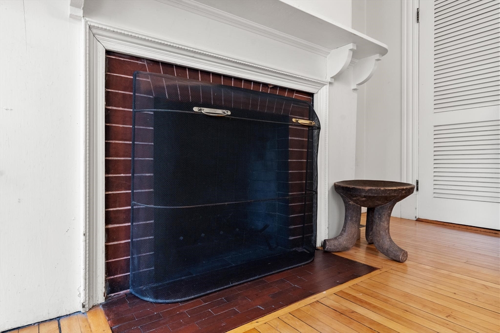 58 Corey Road Brookline, MA 02445 - Photo 4 of 8 a view of a livingroom with wooden floor and a fireplace