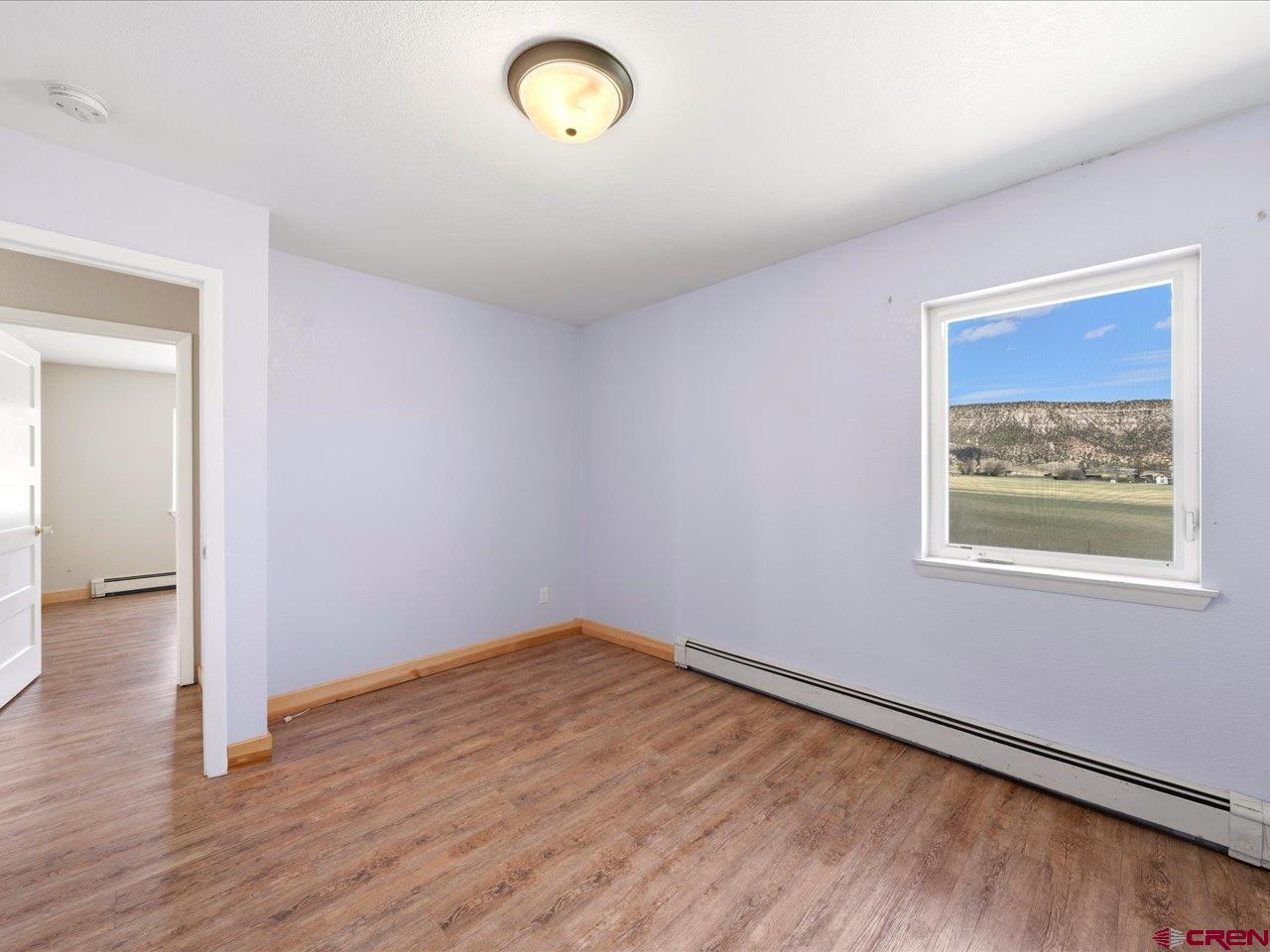 495 North Amelia Street Ridgway, CO 81432 - Photo 22 of 41 an empty room with wooden floor and windows