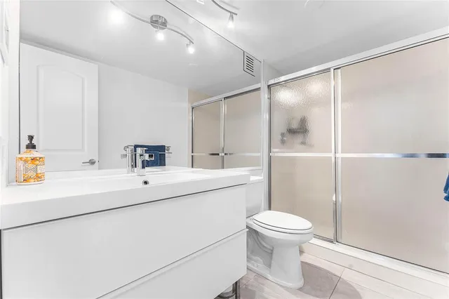 a bathroom with a sink a toilet and shower