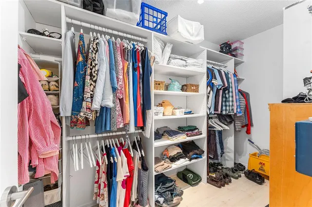 a view of walk in closet with clothes