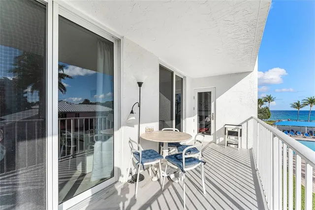 a living room with furniture a large window and stainless steel appliances