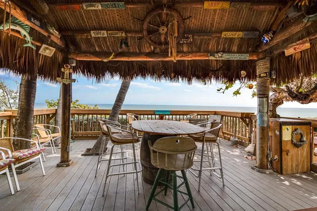 a patio with wooden floor a barbeque grill and outdoor seating