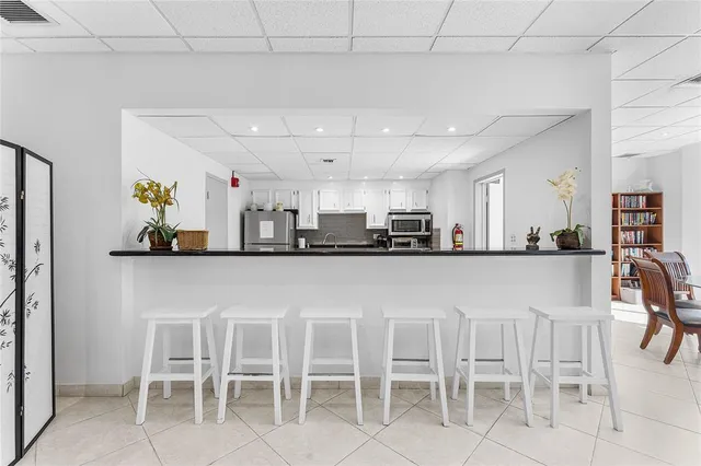 a kitchen with a dining table chairs and view living room