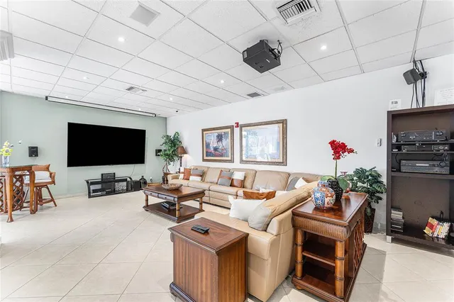 a living room with furniture a flat screen tv and kitchen view
