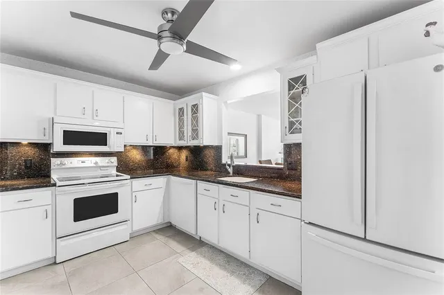 a kitchen with white cabinets and white appliances