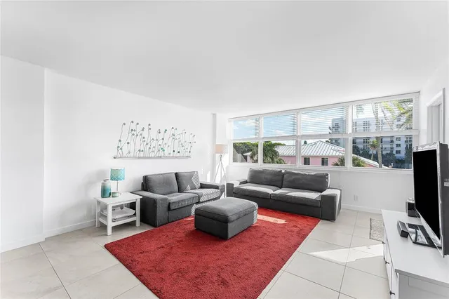 a living room with furniture a rug and a flat screen tv