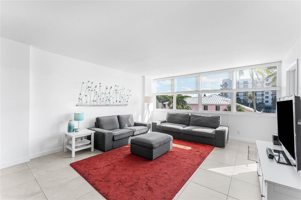 800 Southeast 20th Avenue, Unit 206 Deerfield Beach, FL 33441 - Photo 10 of 37 a living room with furniture a rug and a flat screen tv