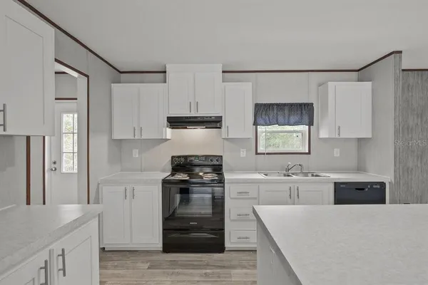 a kitchen with stainless steel appliances granite countertop a refrigerator stove top oven and sink