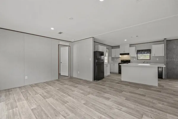 a view of kitchen with stainless steel appliances refrigerator stove microwave and cabinets