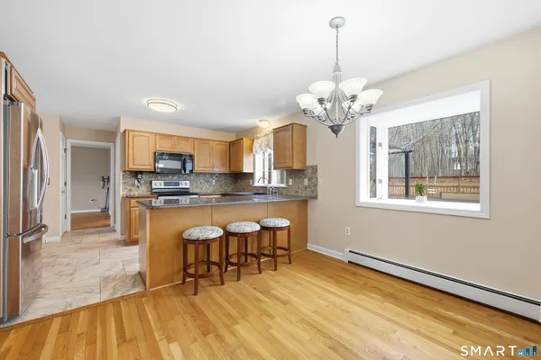 a dining room filled chandelier and wooden floor