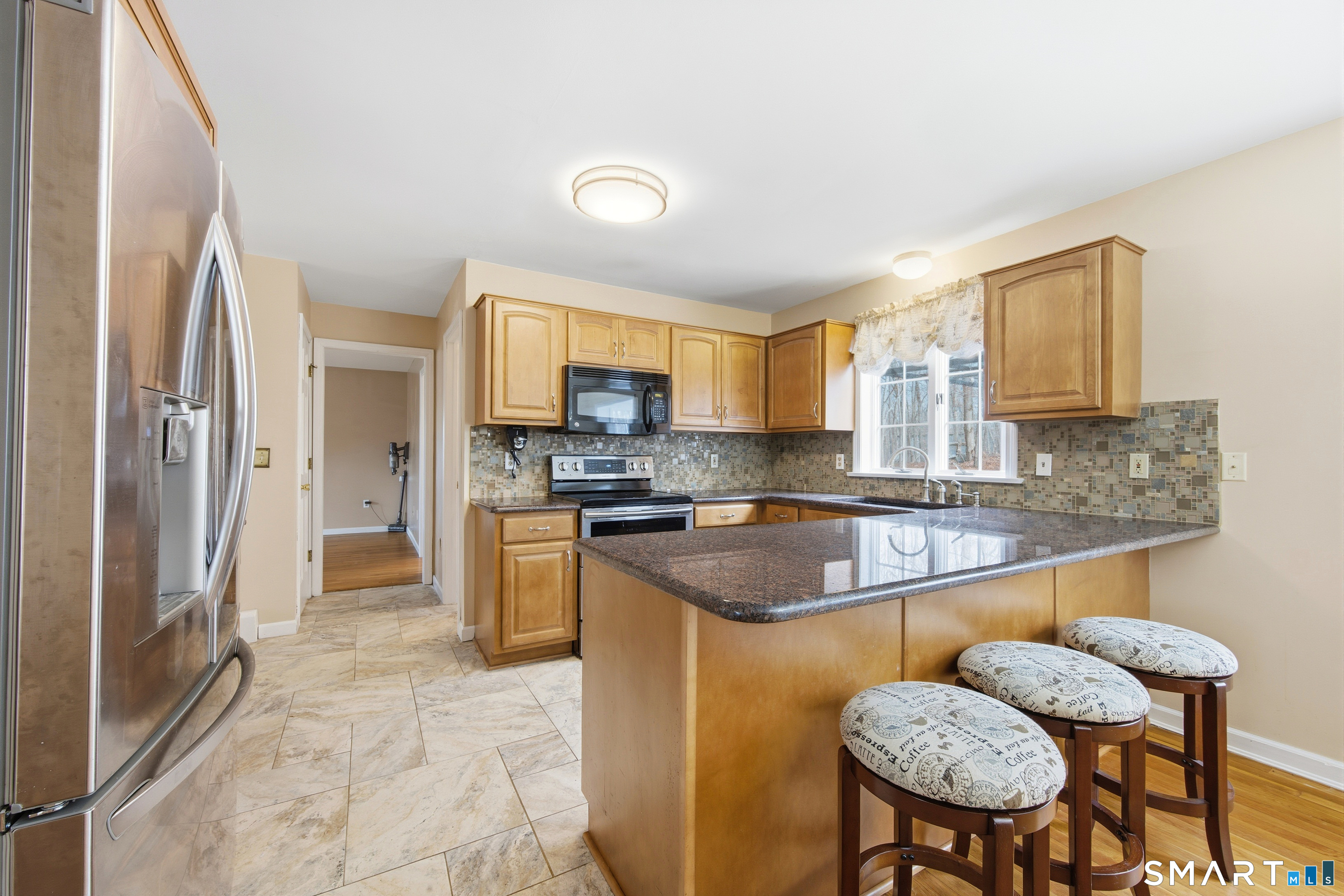 48 Bittersweet Drive Ledyard, CT 06335 - Photo 15 of 38 a kitchen with stainless steel appliances granite countertop a stove a sink dishwasher a refrigerator with a dining table and chairs