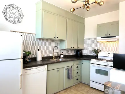 a kitchen with white cabinets and white appliances