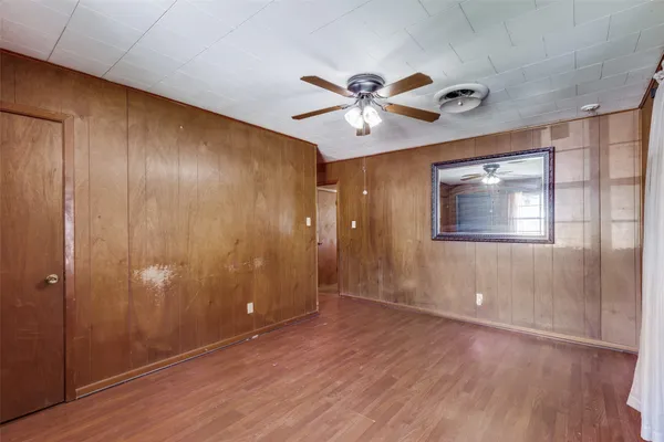 a view of a livingroom with a space wooden floor and fan
